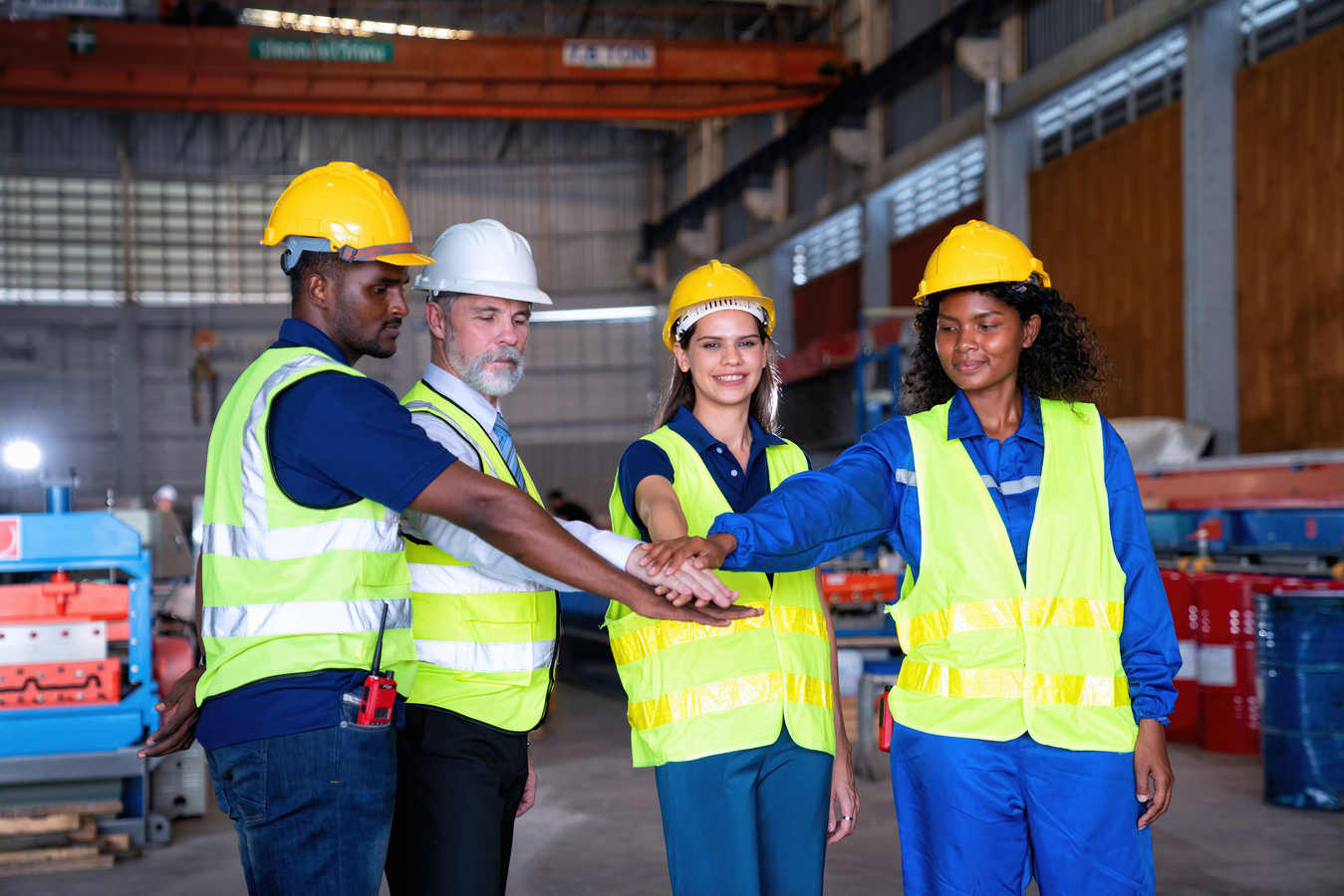 Liderar e Construir - supervisor e seu operários juntando as mãos. simbolizando trabalho de equipe